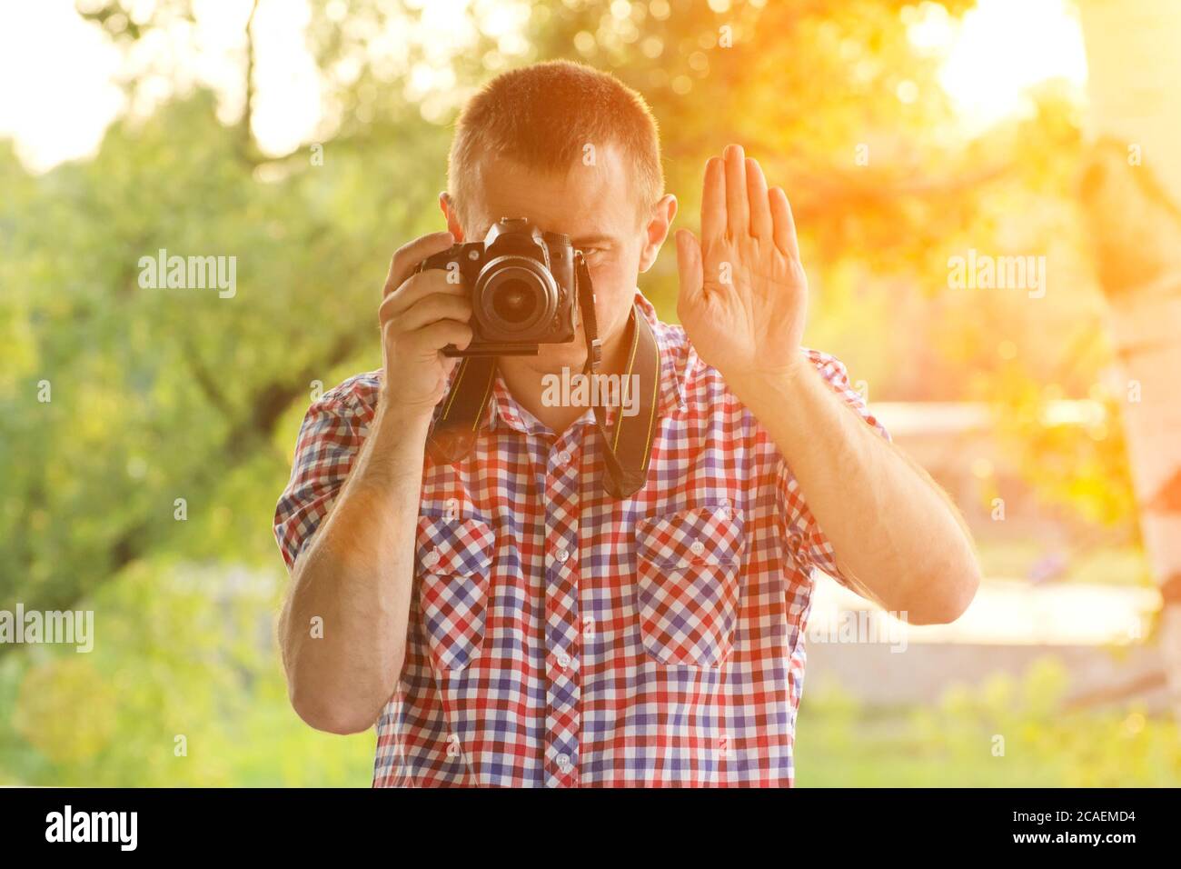 Le photographe prend des photos sur fond de verdure. Vue avant. Arrêter Banque D'Images