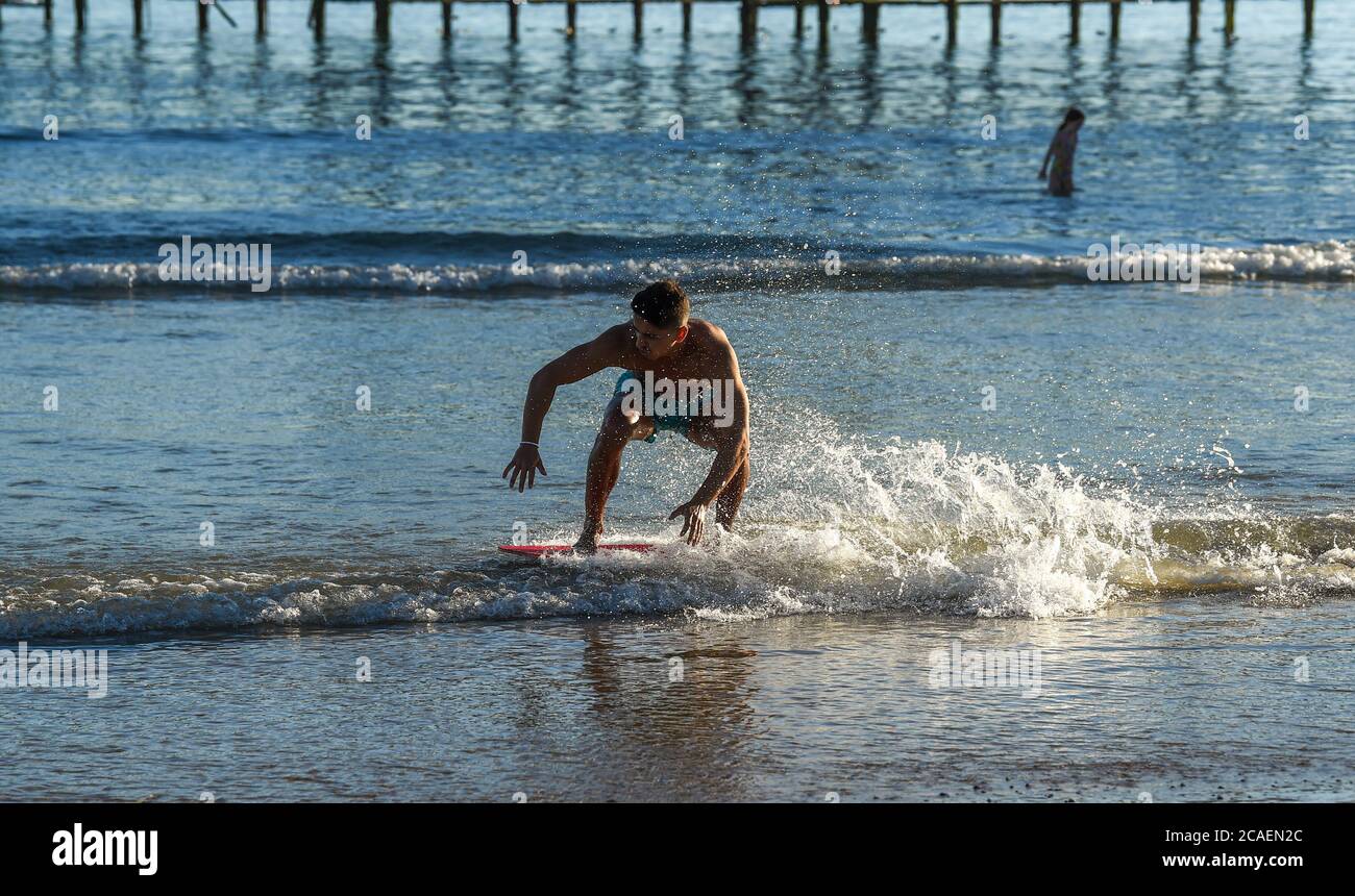 Brighton UK 6 août 2020 - ce jeune homme aime glisser dans la mer sur la plage de Brighton lors d'une belle soirée ensoleillée comme les températures devraient atteindre plus de 30 degrés dans le Sud-est de nouveau demain : crédit Simon Dack / Alay Live News Banque D'Images