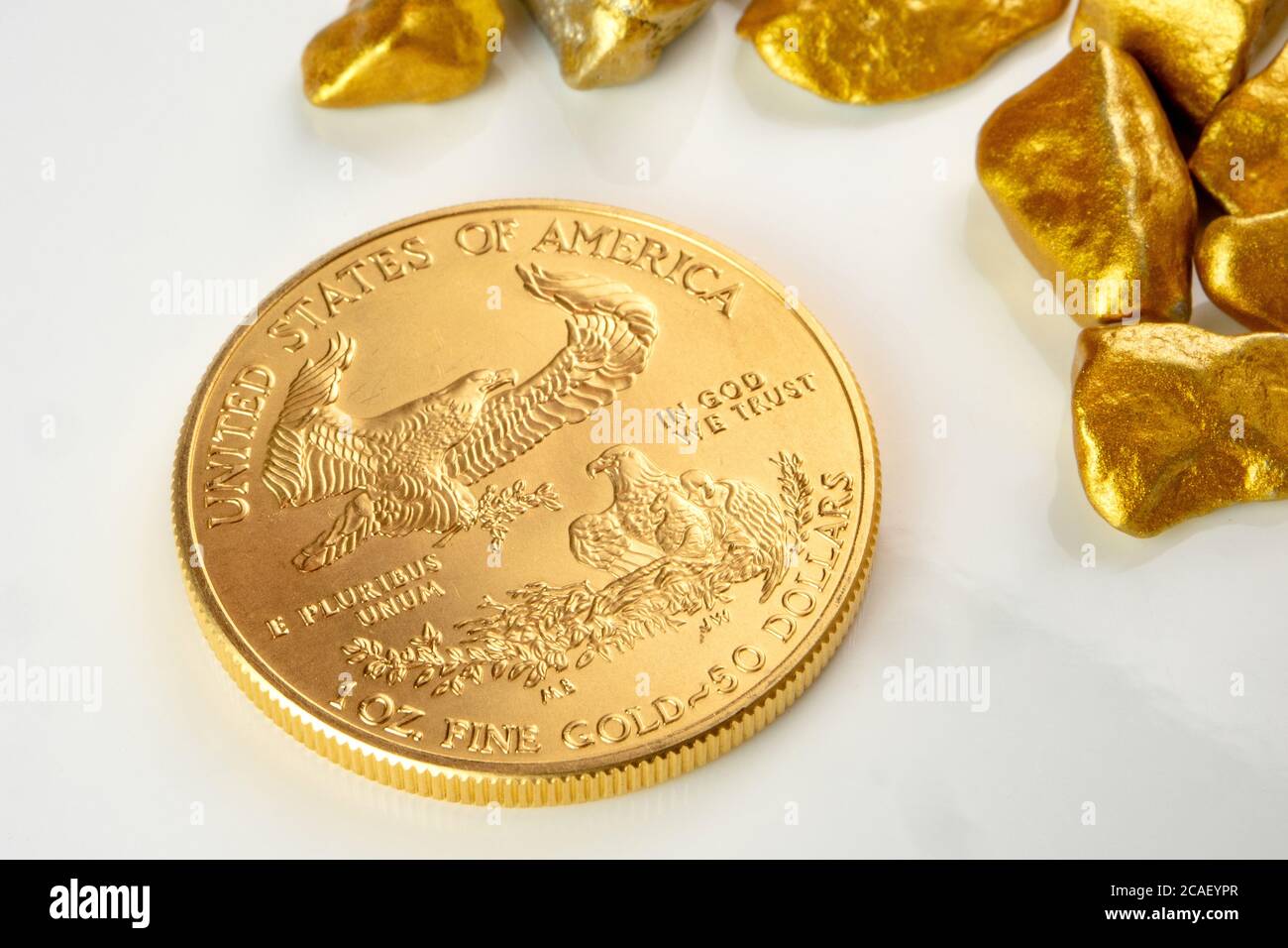 aigle américain d'or pièce d'une once posée sur un tas de nuggets d'or, minerai d'or sur fond blanc isolé avec beaucoup d'espace de copie Banque D'Images