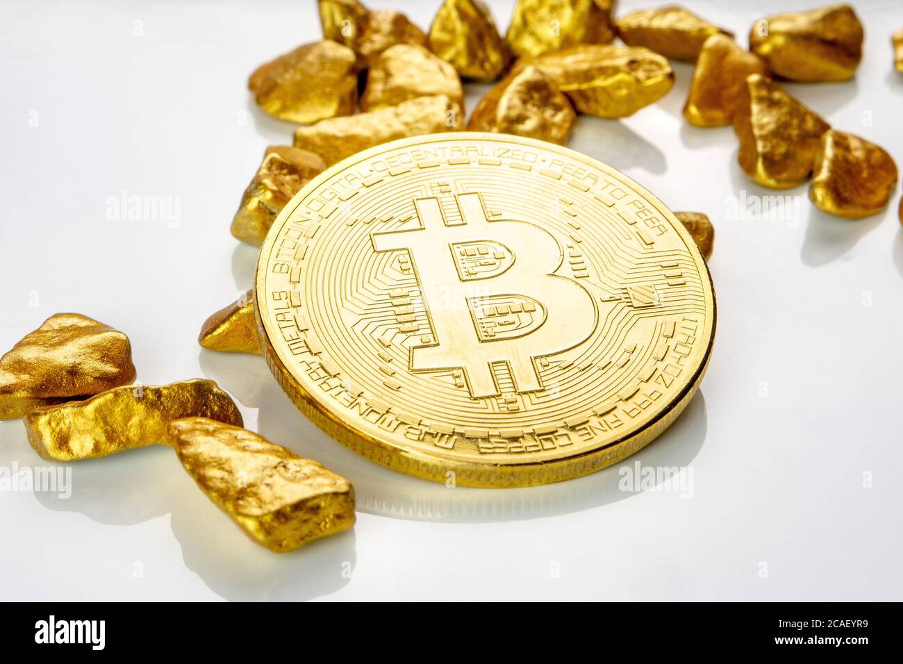 pièce de bitcoin dorée posée sur un tas de nuggets dorés, minerai doré sur fond blanc isolé avec beaucoup d'espace de copie Banque D'Images