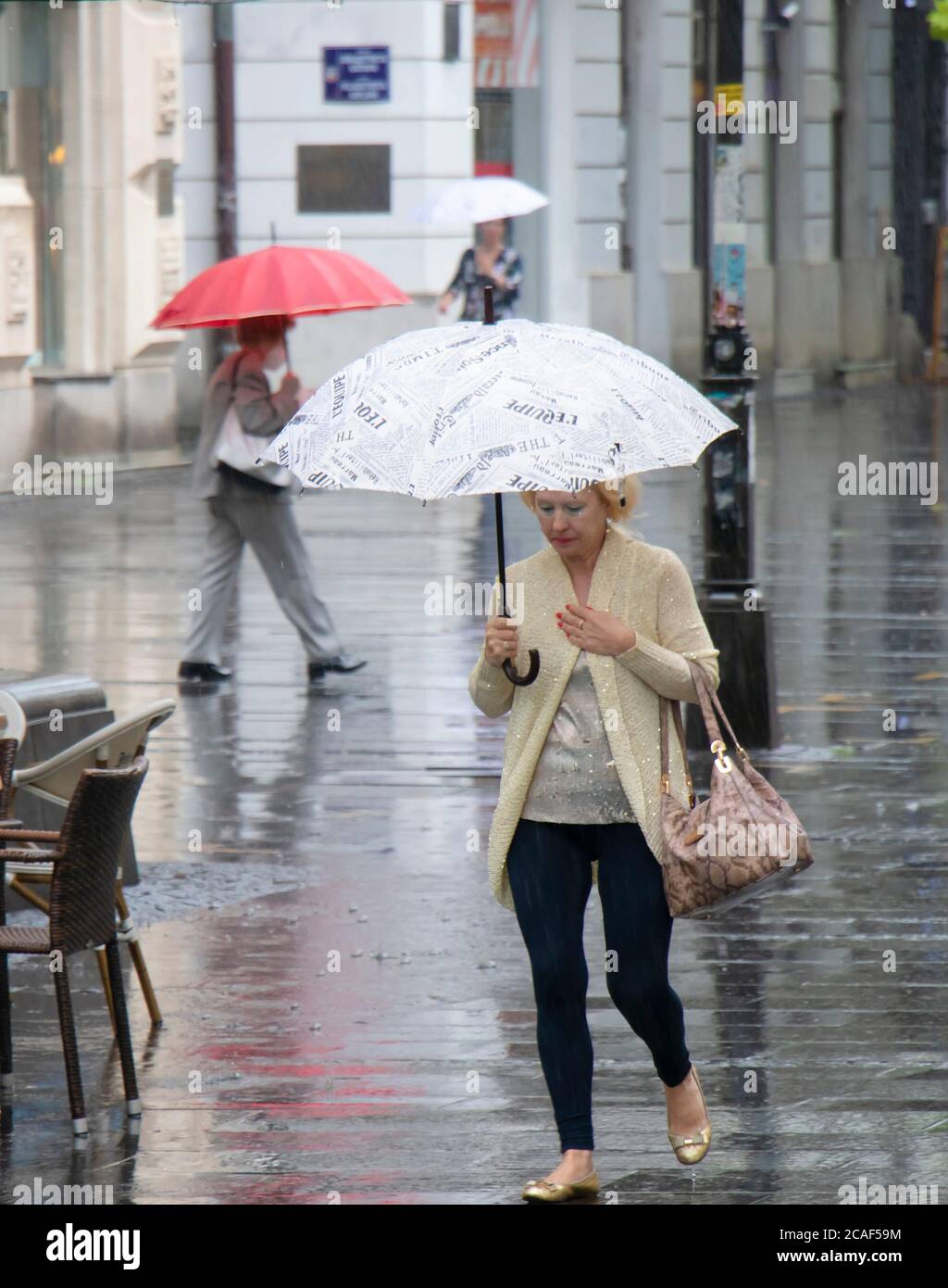 Belgrade, Serbie - 5 août 2020 : femme élégante âgée marchant sous un parapluie lors d'une journée pluvieux d'été dans la ville Banque D'Images