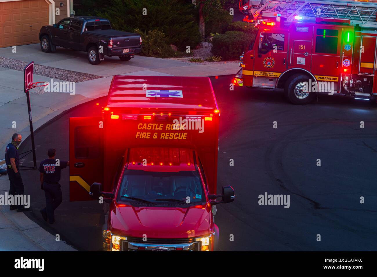 La nuit, deux ambulanciers paramédicaux attendent que l'homme âgé soit emmené de sa maison dans leur ambulance pour le transit vers un hôpital, Castle Rock Colorado USA. Banque D'Images
