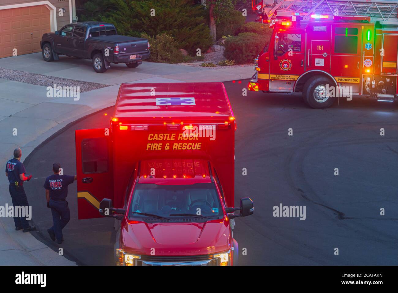 La nuit, deux ambulanciers paramédicaux attendent que l'homme âgé soit emmené de sa maison dans leur ambulance pour le transit vers un hôpital, Castle Rock Colorado USA. Banque D'Images