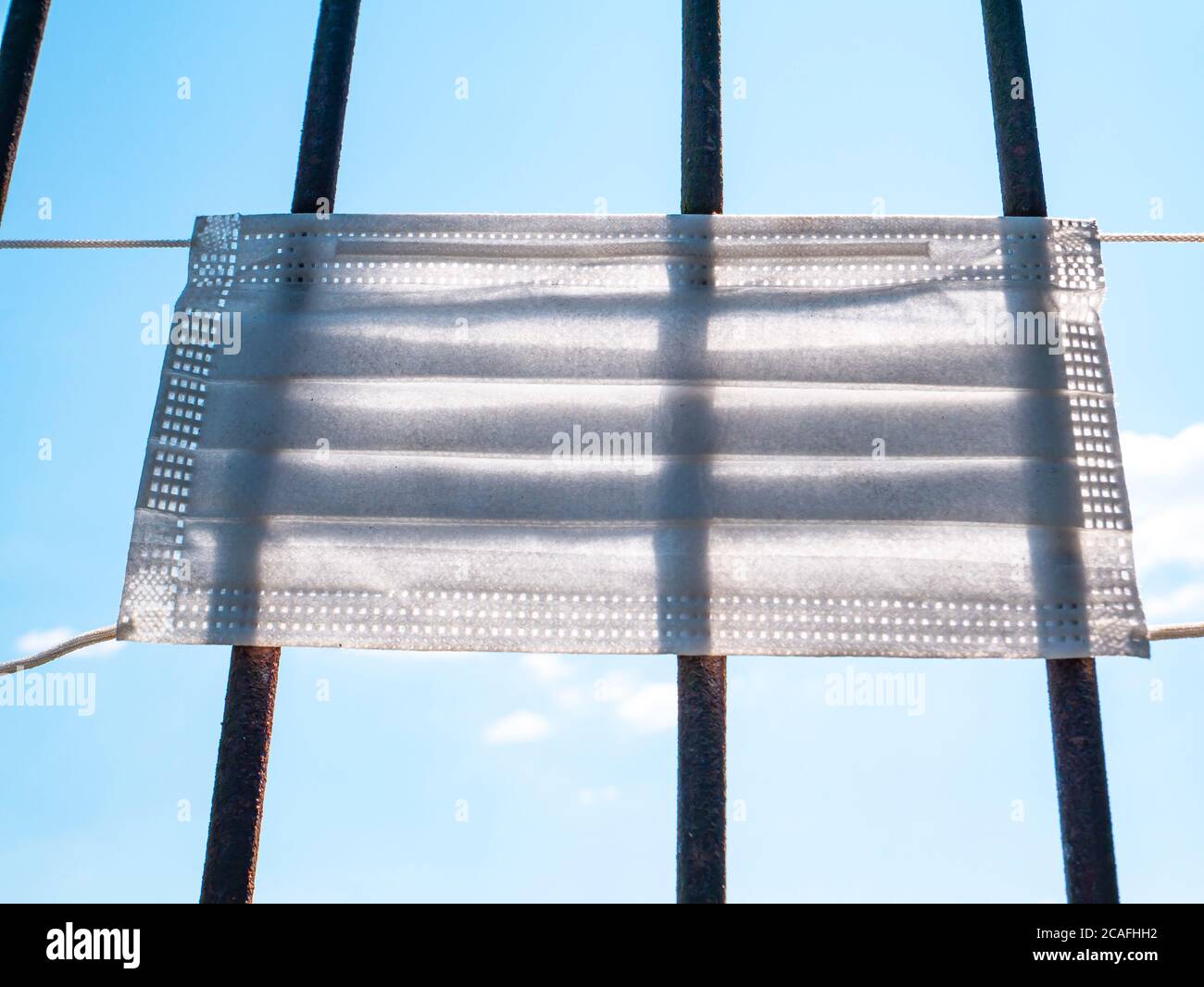 Masque médical sur une grille en fer. Banque D'Images