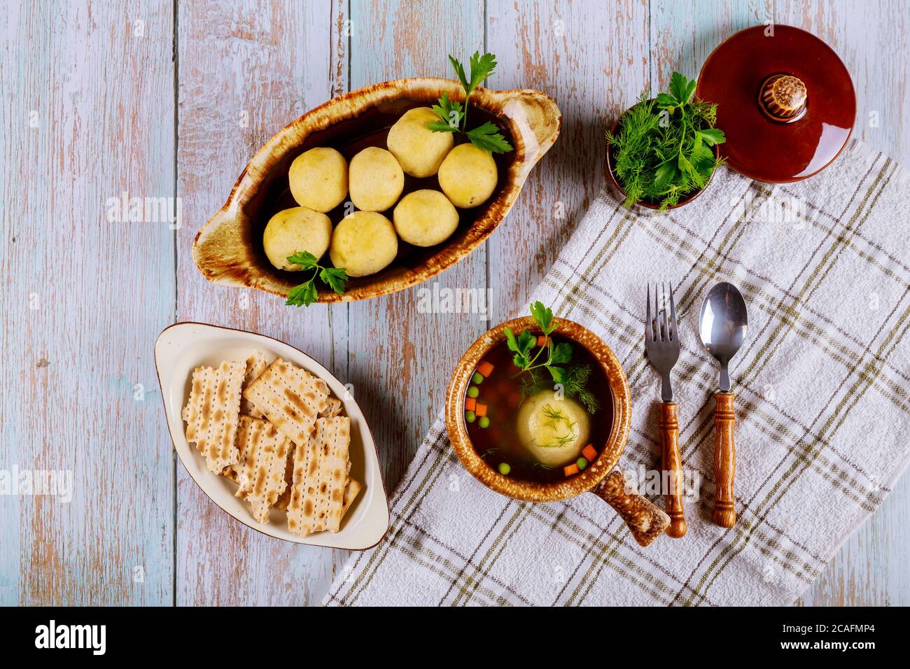 Soupe juive traditionnelle de matzah, boulettes de matzo et de matzo avec persil, aneth et carotte. Banque D'Images