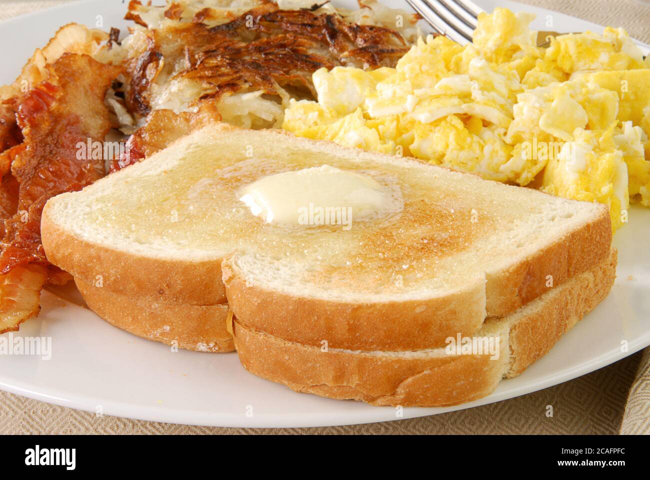 Un petit-déjeuner composé de pain grillé, de bacon et d'œufs brouillés Banque D'Images