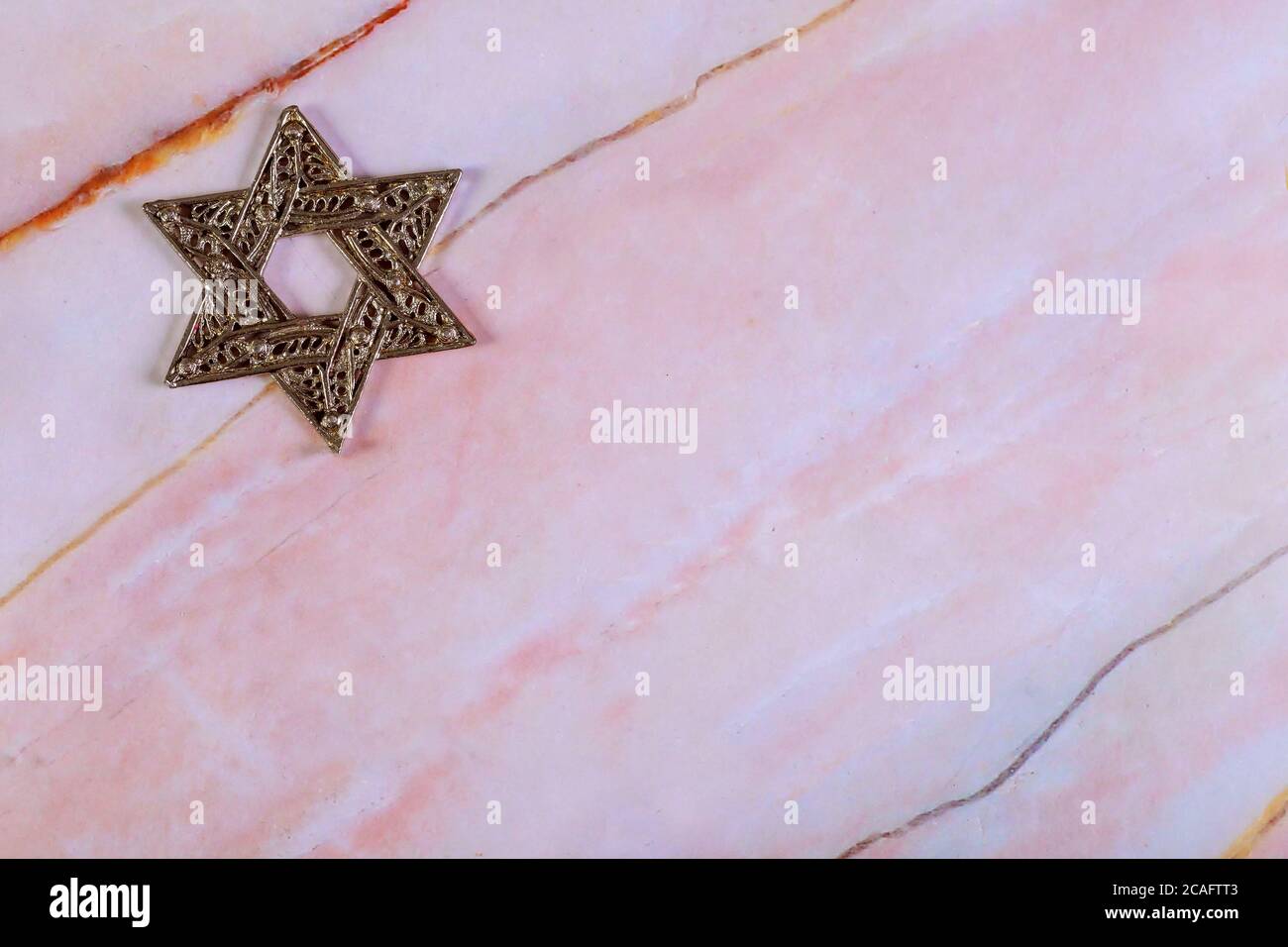 Symbole juif étoile de David sur fond de granit rose. Banque D'Images