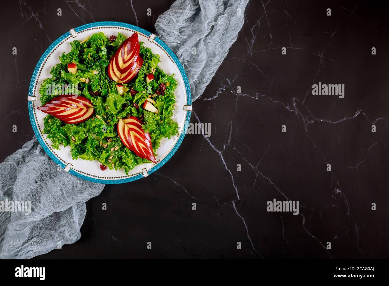 Salade saine de forme physique avec kale vert et pomme sur fond noir. Banque D'Images