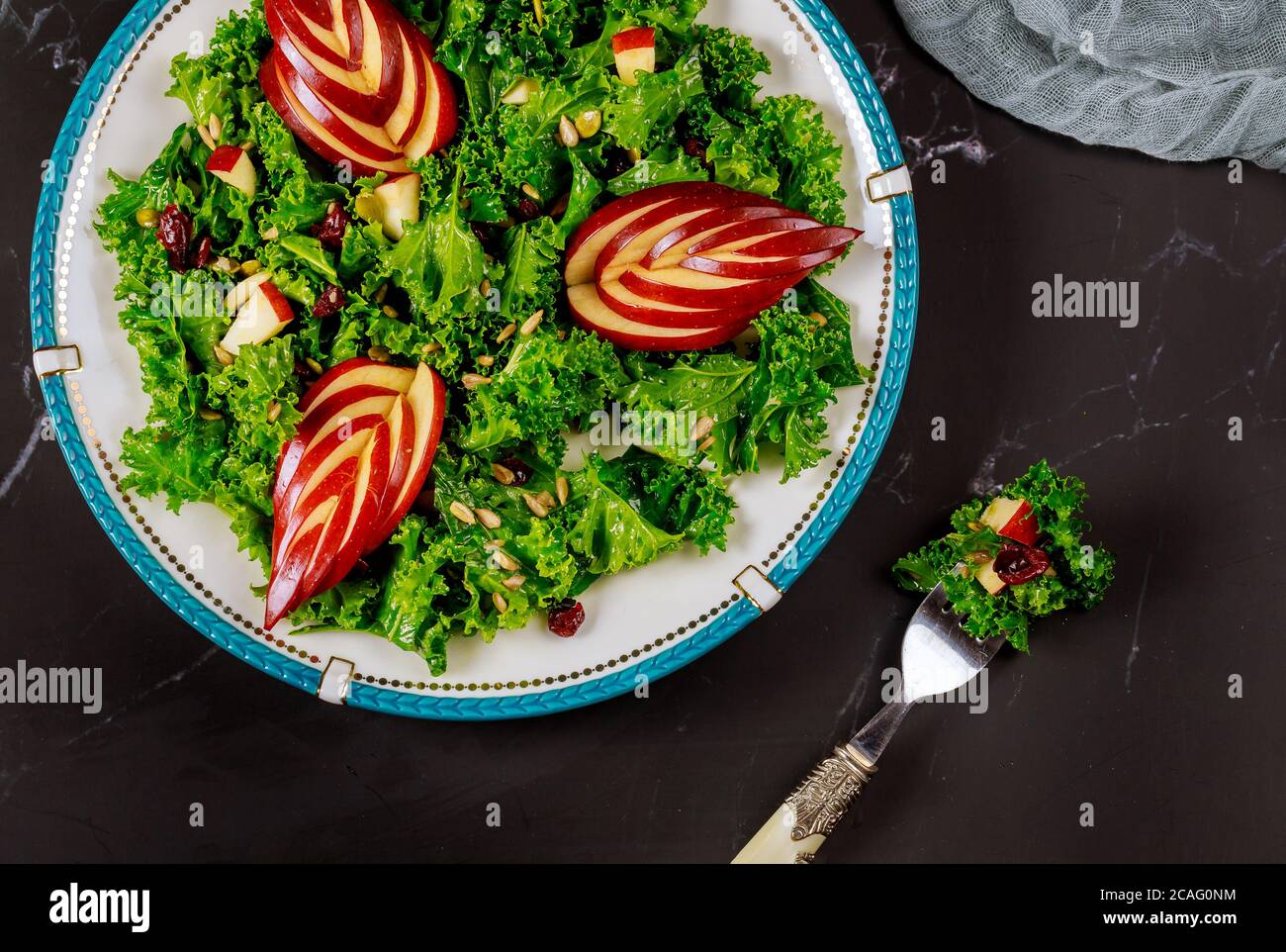 Belle salade de kale fraîche avec des tranches de pomme rouge et de canneberge. Banque D'Images