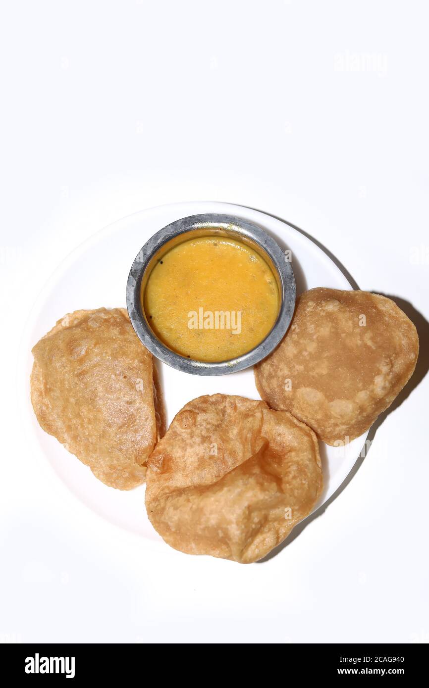 Poori Saagu - délicieux poori frits (puri) servi avec curry de pommes de terre épicé sur fond blanc Banque D'Images