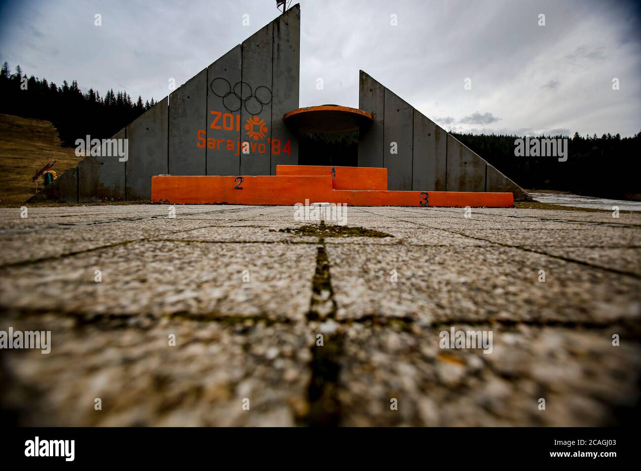 Podium en béton pour les gagnants avec texte écrit 'Jeux Olympiques d'hiver 1984' debout abandonné près des collines de saut à Mt. Igman près de Sarajevo Banque D'Images