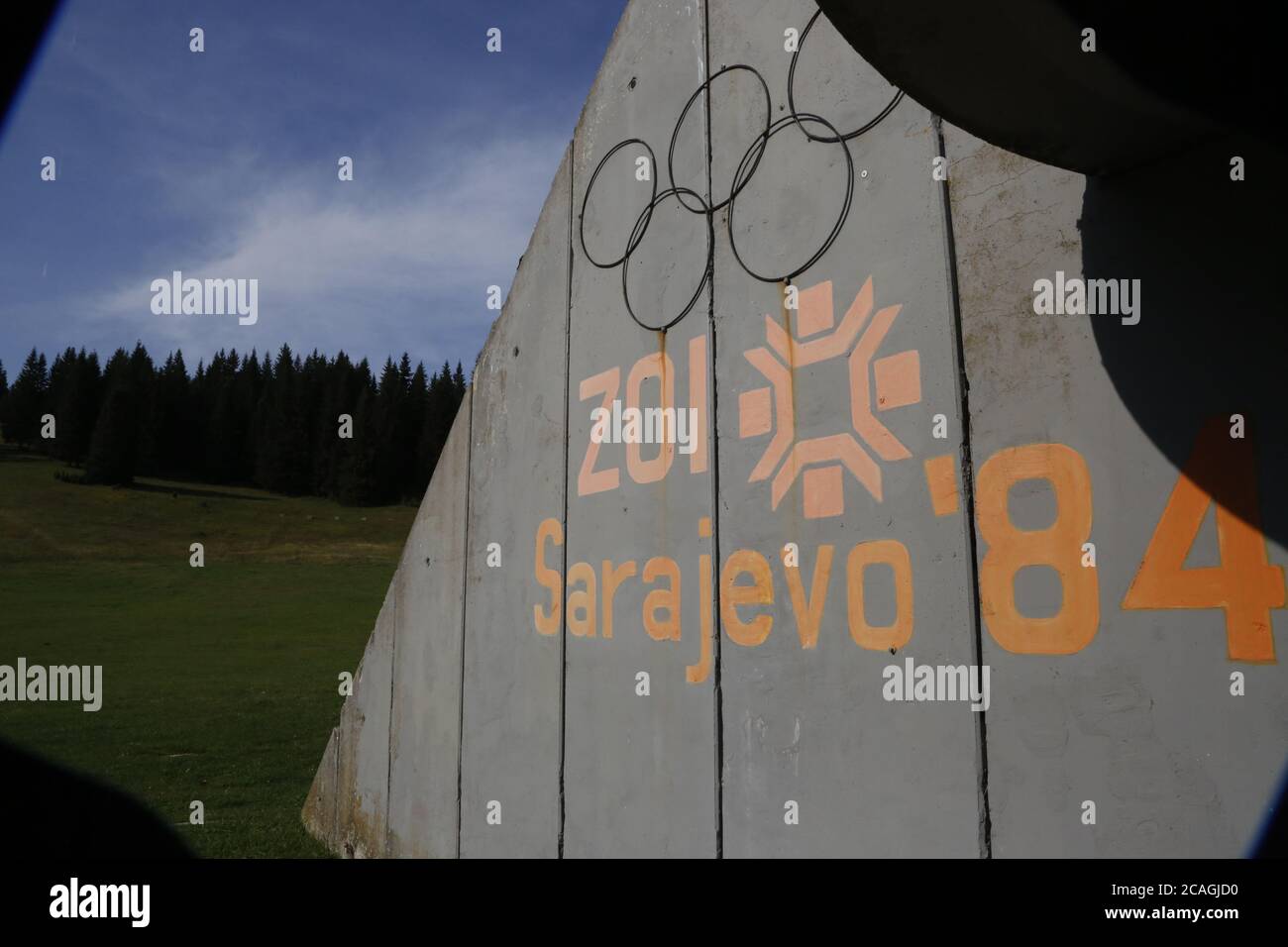 Podium en béton pour les gagnants avec texte écrit 'Jeux Olympiques d'hiver 1984' debout abandonné près des collines de saut à Mt. Igman près de Sarajevo Banque D'Images