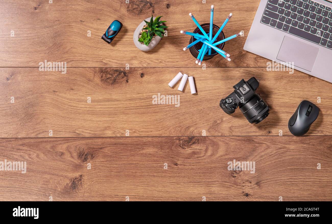 Les photographes et les graphistes travaillent. Plan de travail avec vue sur le bureau, ordinateur portable et appareil photo. Espace de copie de table en bois. Banque D'Images