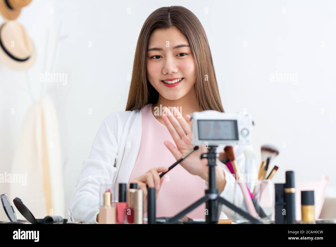 Belle beauté asiatique vlogger influenceur en direct de diffusion en face de appareil photo à la maison Banque D'Images