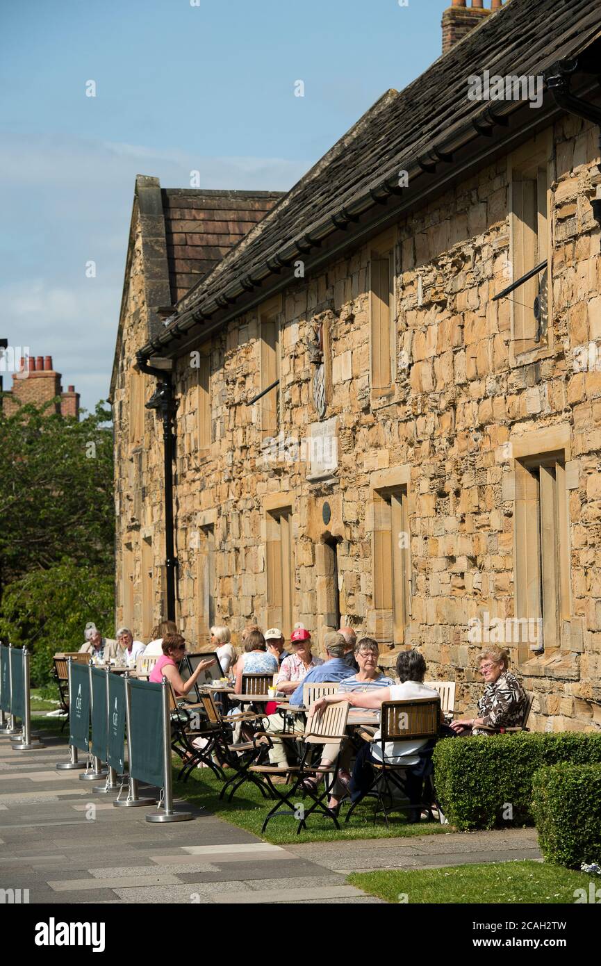 Les visiteurs dînant en plein air au Durham University café on the Green dans des almshres historiques à l'extérieur de la cathédrale. Banque D'Images