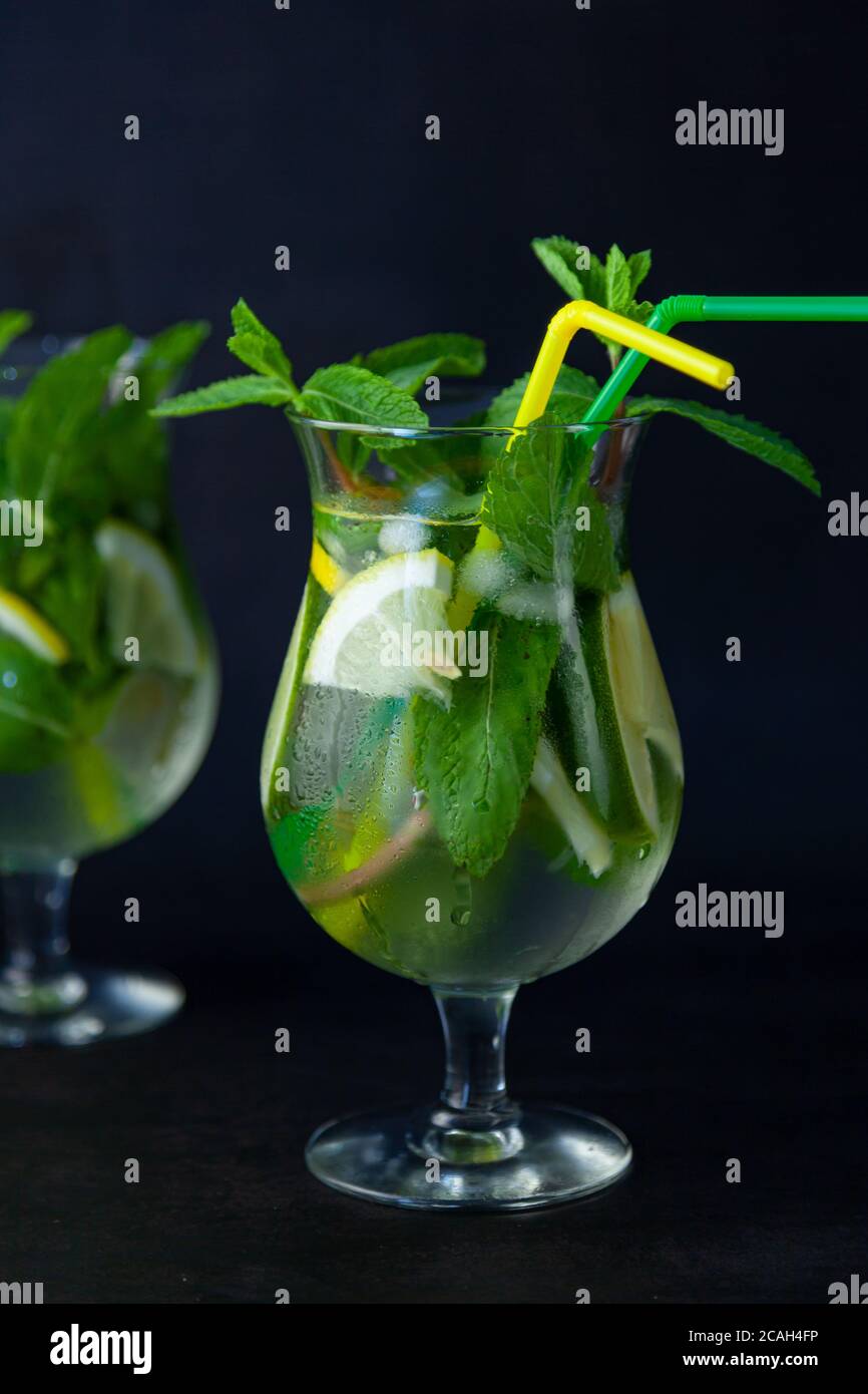 Cocktail mojito rafraîchissant à la menthe d'été avec rhum et glace sur fond noir. Cocktail Mojito sur une table en pierre sombre. Verre haut vitreux pour Banque D'Images