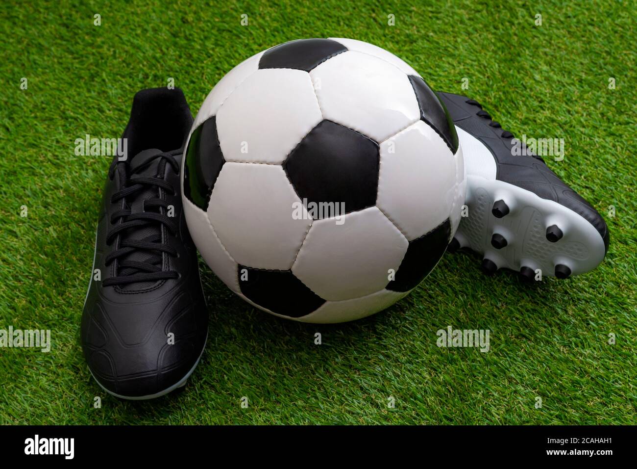 Équipement sportif, compétition d'athlétisme et concept d'événement sportif avec ballon de football, crampons en cuir ou chaussures de football sur gazon vert Banque D'Images