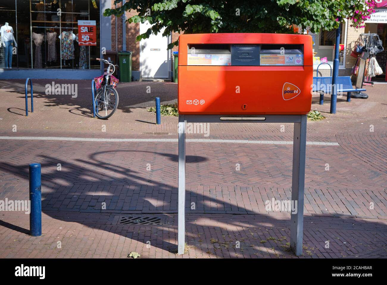 Benekom,pays-Bas-juillet,30,2020:boîte aux lettres rouge hollandaise, par la société de logistique PostNL dans un quartier de banlieue de rue commerçante. Boîte aux lettres Banque D'Images