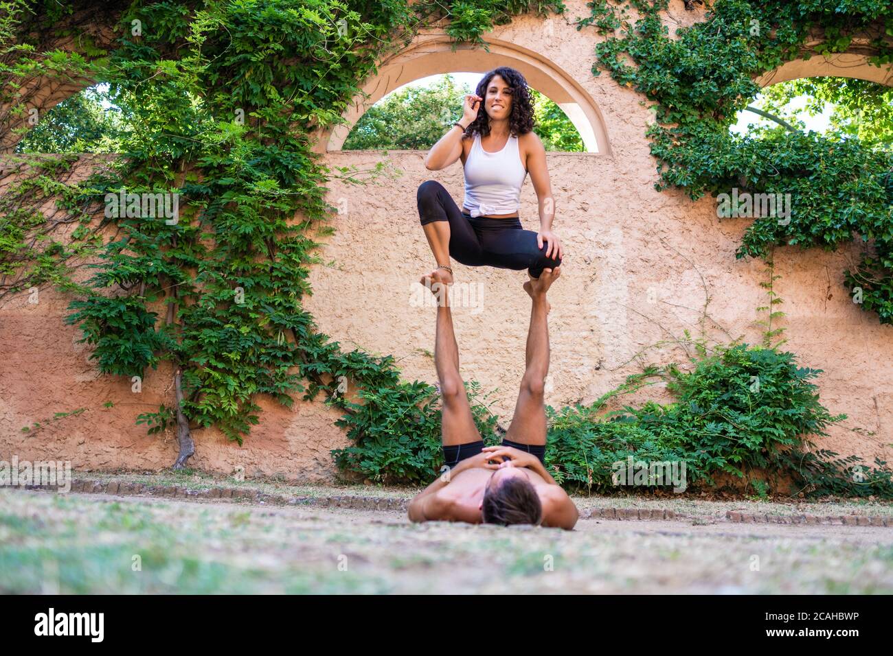 Deux belles femmes faisant acroyoga dans le jardin ou le parc Banque D'Images