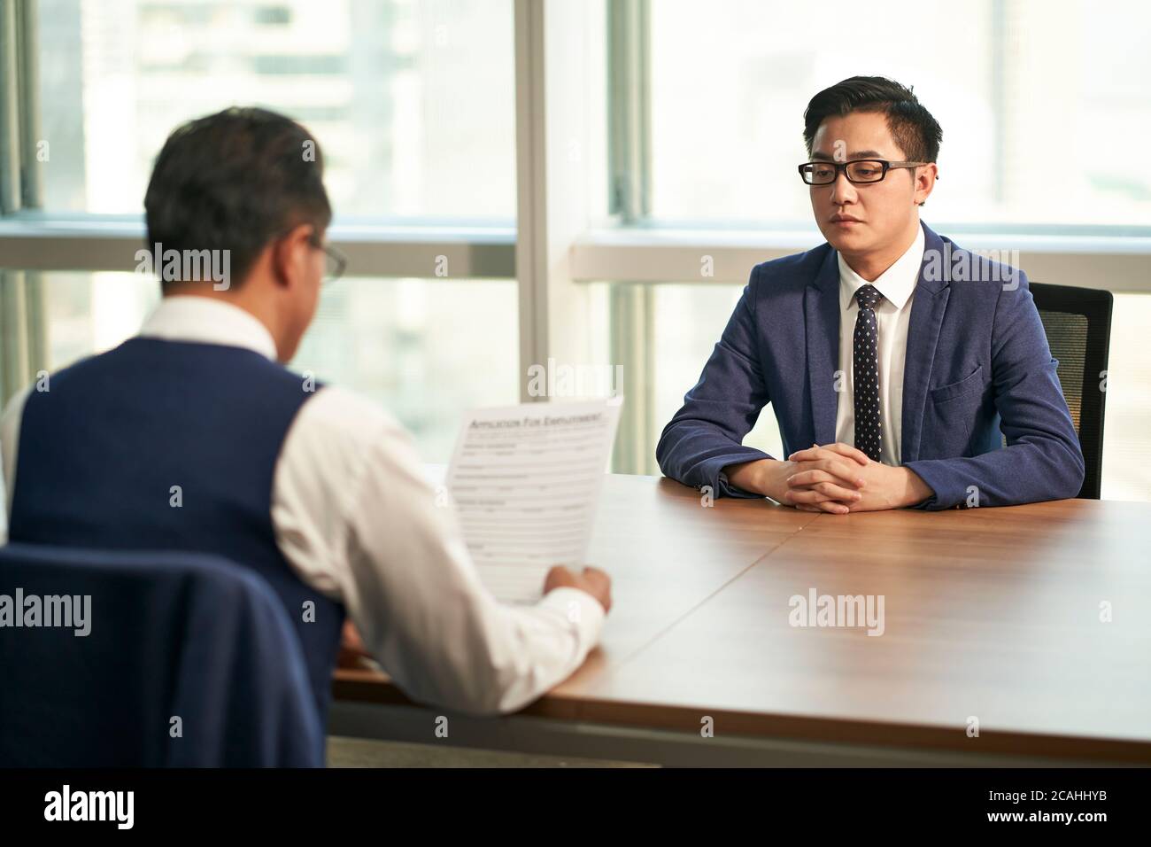 un jeune homme asiatique interviewé par le directeur des ressources humaines de l'entreprise Banque D'Images