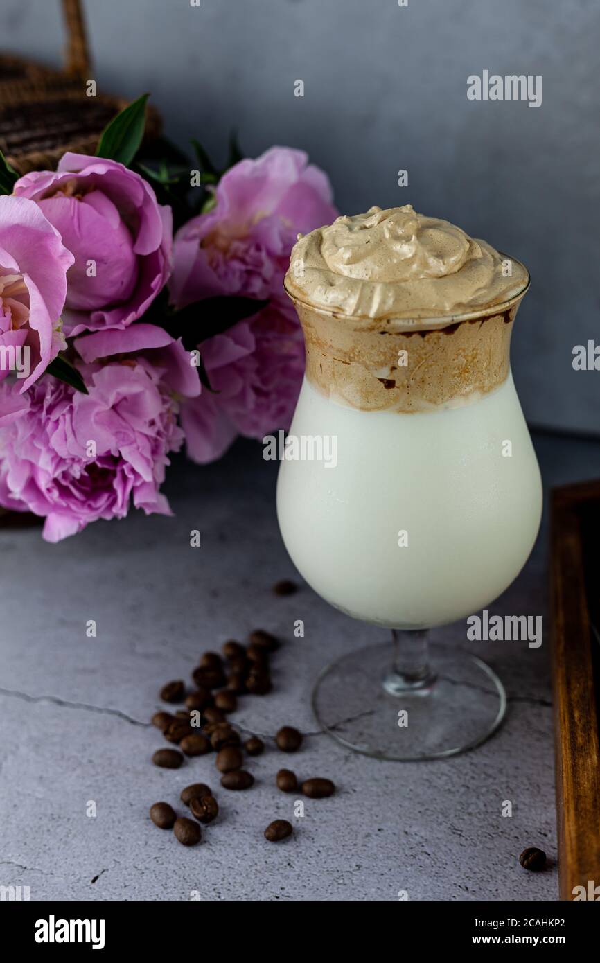 Milk shake. Dalgona Coffee - le café coréen est servi sur fond de bois. Café instantané ou espresso en poudre fouetté avec du sucre et de l'eau chaude. Glacé Banque D'Images