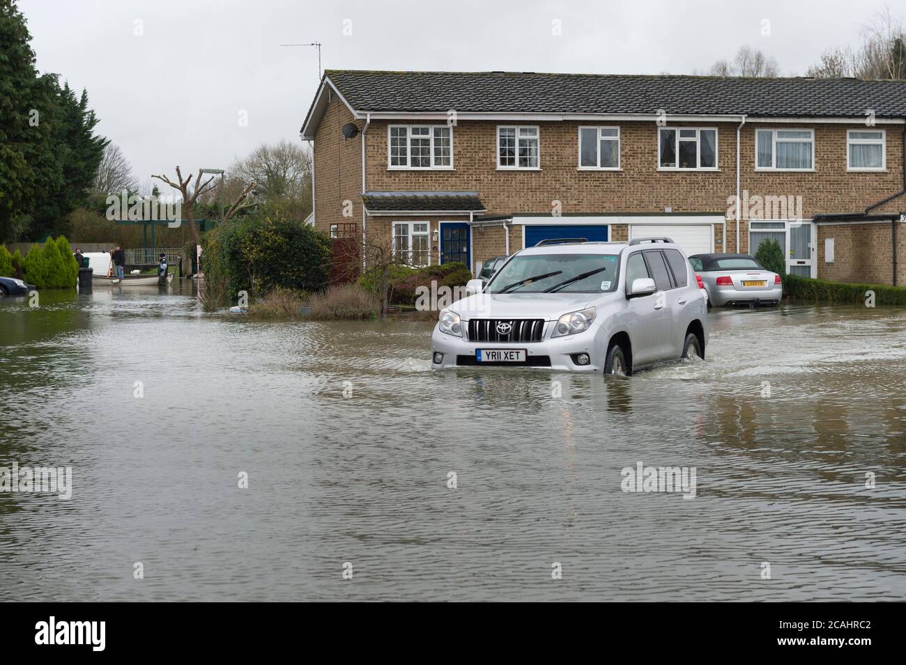 Une voiture traversant les eaux d'inondation sur Aymer Drive, Egham Hythe, Surrey, après que la Tamise l'ait brisée, Aymer Drive, Egham Hythe, Surrey, Royaume-Uni. 14 févr. 2014 Banque D'Images