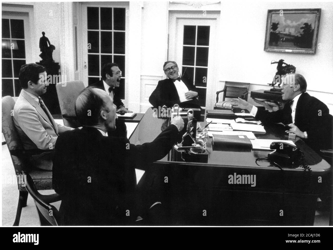 Dans ce dossier photo, le président américain Gerald R. Ford (à droite) profite d'un moment de lumière avec son personnel supérieur dans le bureau ovale de la Maison Blanche le 14 mai 1975. (De gauche à droite) Robert (Bud) McFarlane, conseiller à la sécurité nationale Brent Scowcroft, Donald Rumsfeld, chef de cabinet à la Maison-Blanche, et Henry Kissinger, secrétaire d'État des États-Unis. Crédit obligatoire : David Hume Kennerly / Maison-Blanche via CNP / MediaPunch Banque D'Images