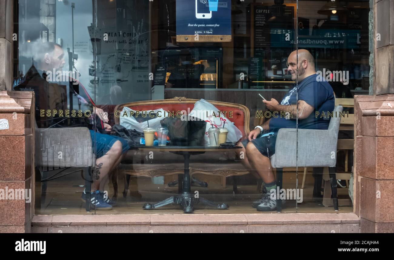 Glasgow, Écosse, Royaume-Uni. 7 août 2020. Météo Royaume-Uni. Clients dans la fenêtre de Caffe Nero sur Trongate ayant un café. Credit: SKULLY/Alay Live News Banque D'Images