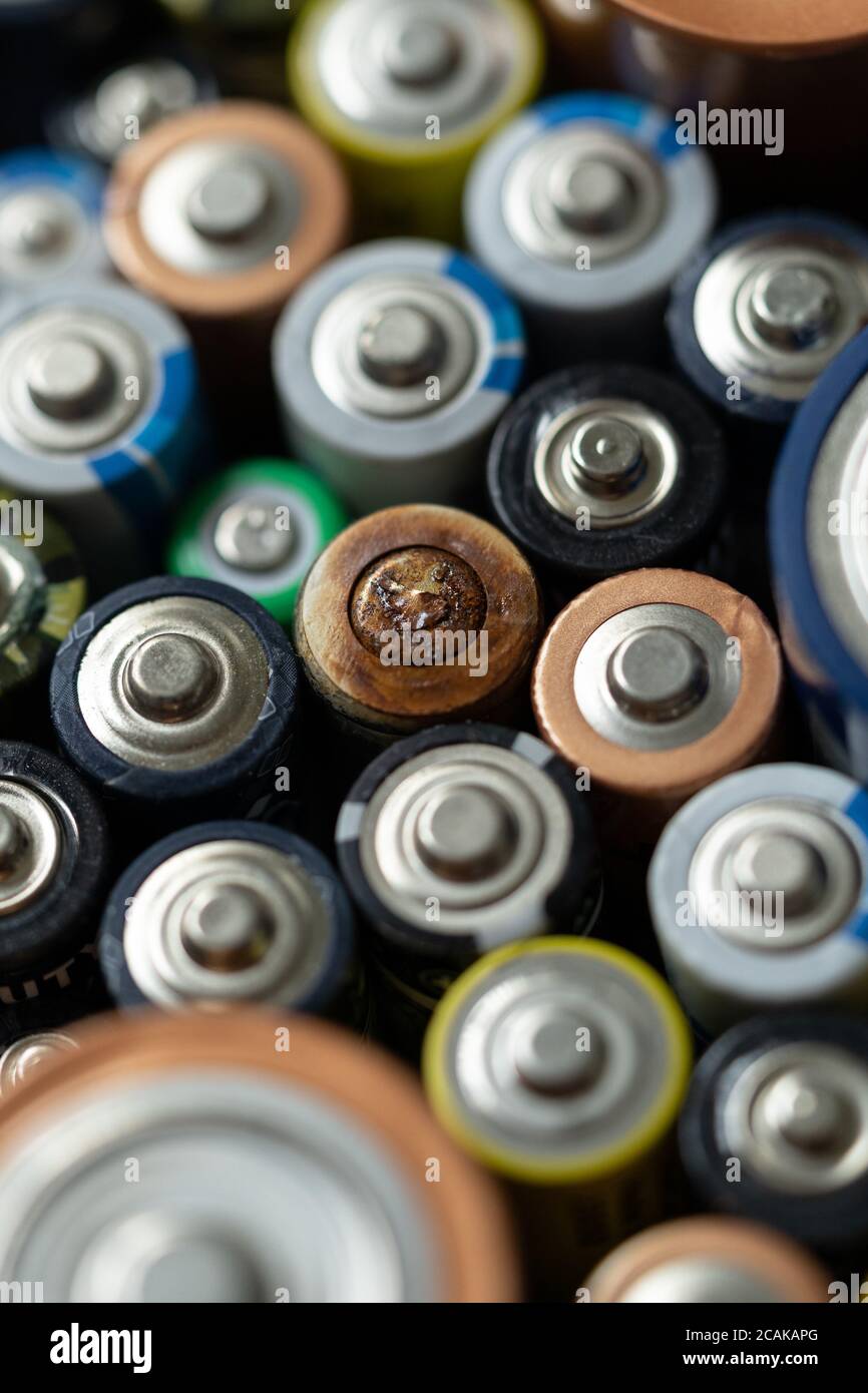 Gros plan des extrémités positives des batteries déchargées de différentes tailles et formats, mise au point sélective. Batterie usagée corrodée et rouillée. Risque d'accident Banque D'Images
