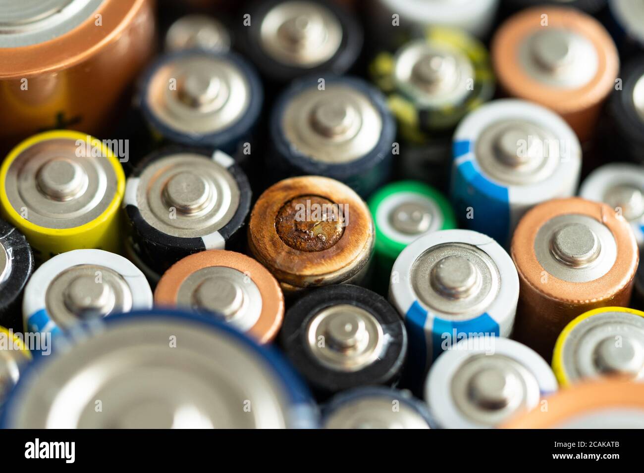 Gros plan des extrémités positives des batteries déchargées, mise au point sélective, photo macro. Pile alcaline usagée corrodée et rouillée. Déchets dangereux conc Banque D'Images