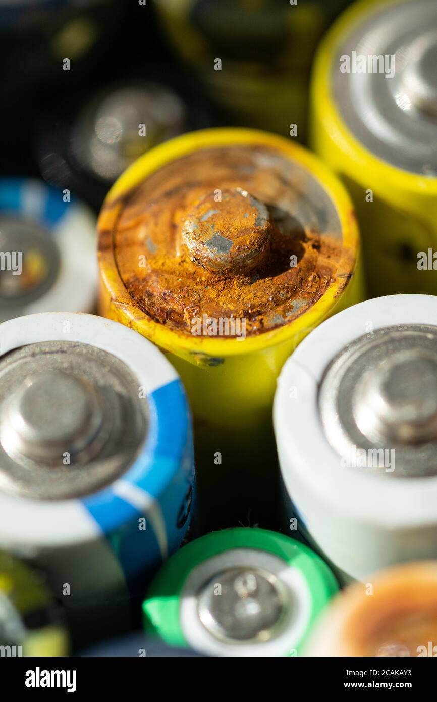 Gros plan des extrémités positives des batteries déchargées de différentes tailles et formats, mise au point sélective. Batterie usagée corrodée et rouillée. Risque d'accident Banque D'Images