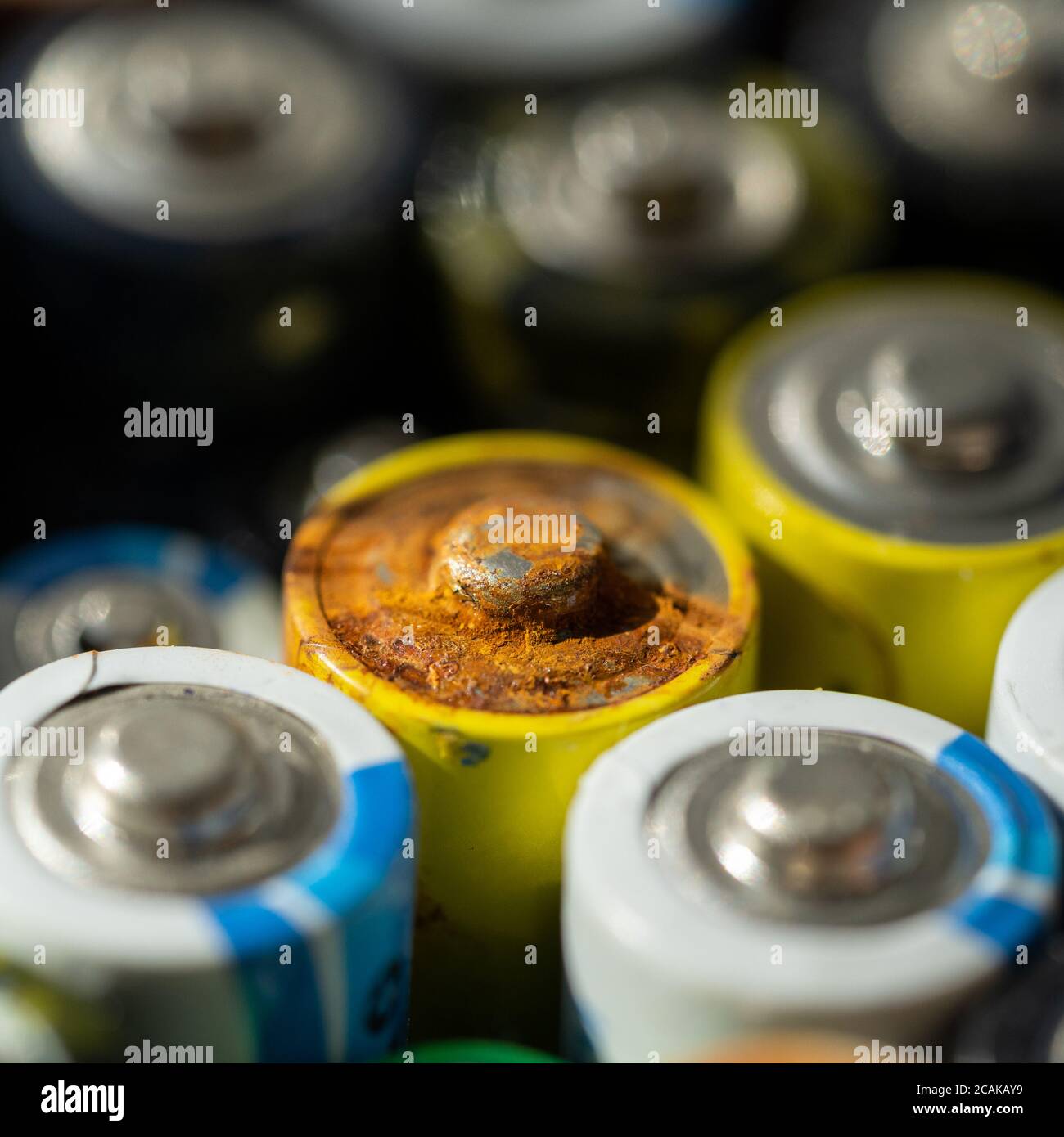 Gros plan des extrémités positives des batteries déchargées de différentes tailles et formats, mise au point sélective. Batterie usagée corrodée et rouillée. Risque d'accident Banque D'Images