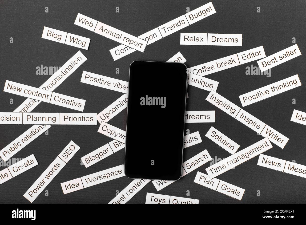 Smartphone entouré d'un nuage de mots sur des thèmes professionnels, coupé de papier sur fond gris, Banque D'Images