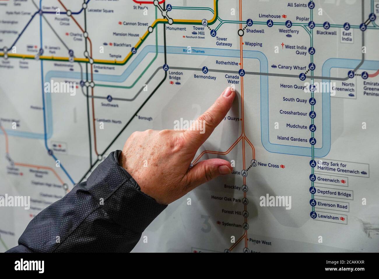 London, Royaume-Uni - le 02 février 2019 : une femme âgée pointe de la main vers la station d'eau du Canada sur la carte du métro de Londres, alors qu'elle planifie son voyage. Sous-groupe Banque D'Images