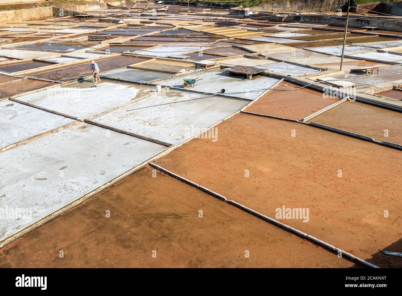 Vue sur les salines à Rio Maior, au Portugal, avec un ouvrier de sel qui joint le sel avec une pelle. Banque D'Images