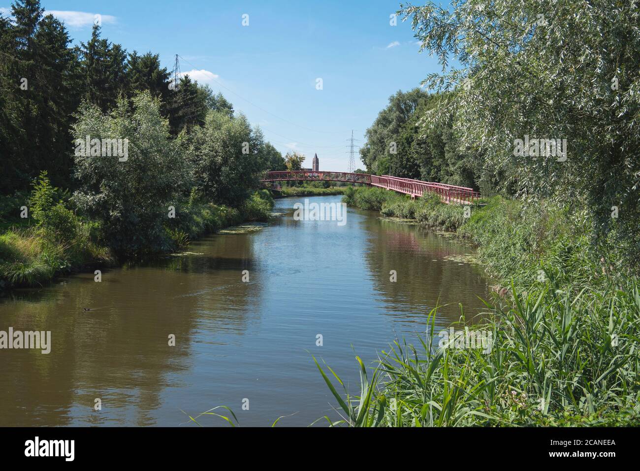 Lokeren, Belgique, photo de paysage avec une rivière, une passerelle et une tour d'église au loin Banque D'Images