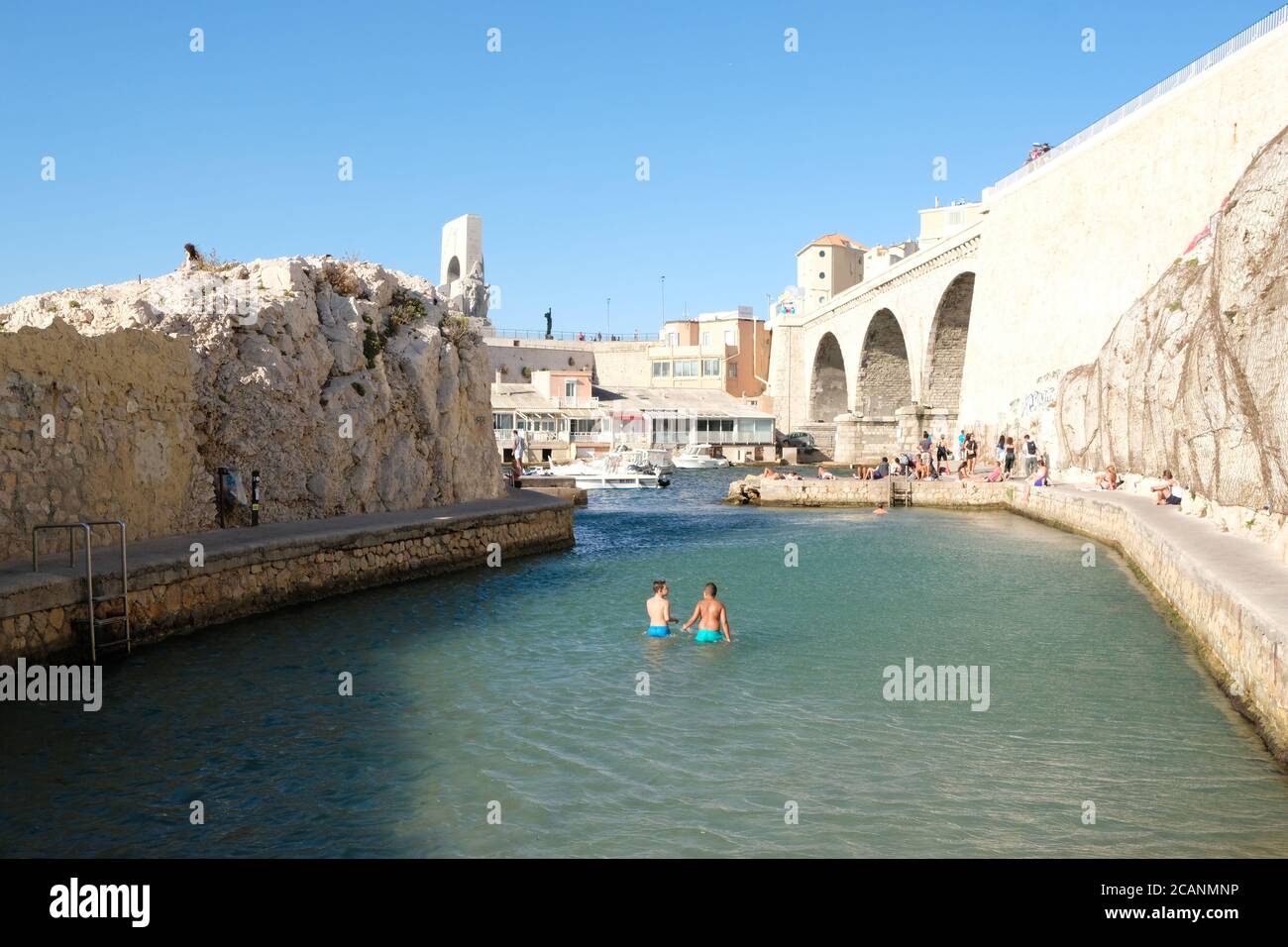 Vue sur la crique protégée à l'entrée du Vallon des Auffes, vue sur le pont et les personnes méconnaissables se baignant dans la mer Banque D'Images