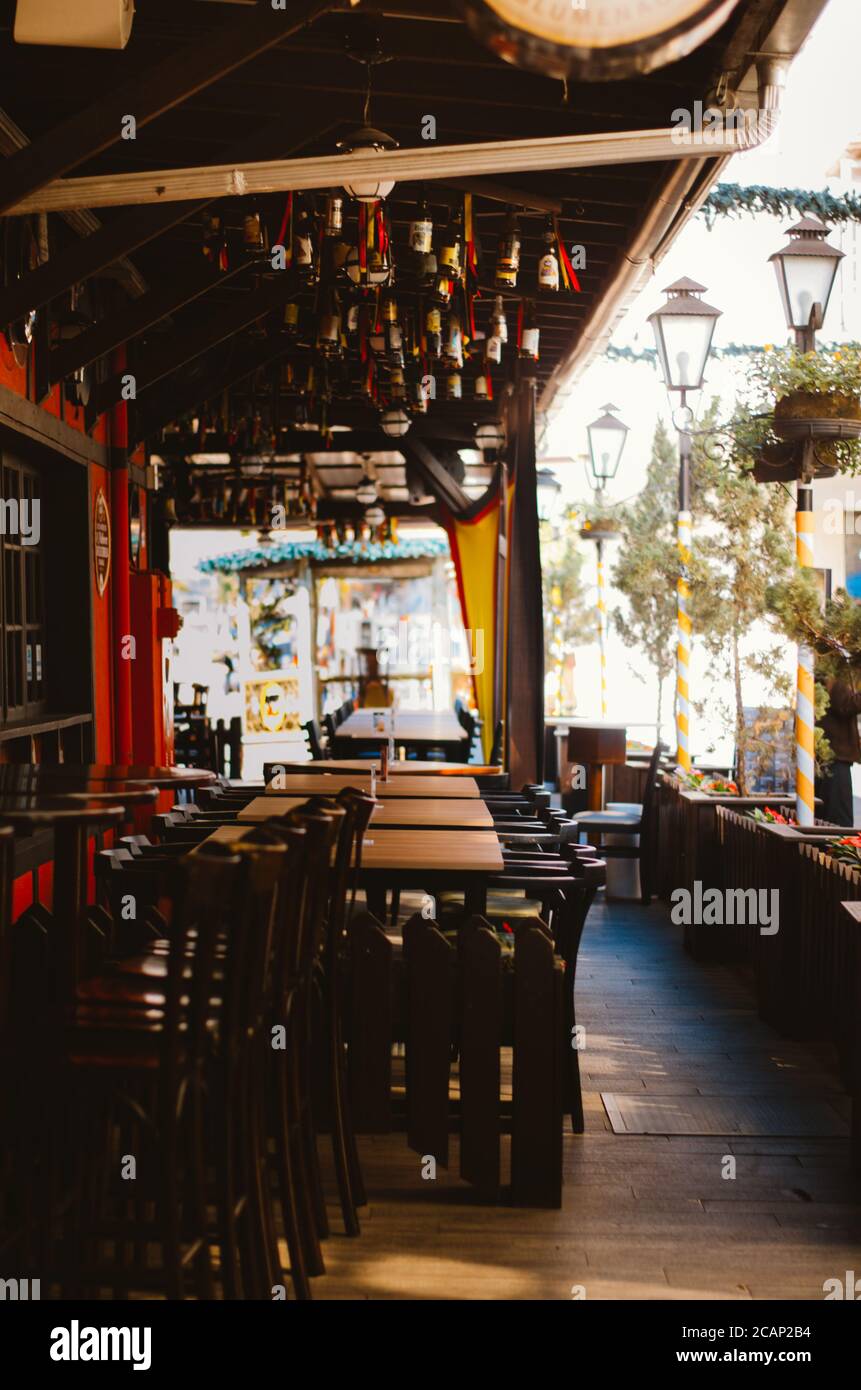 Chandelier composé de bouteilles de bière, chaises et tables d'un restaurant vide à Vila Germanica, Blumenau - Brésil pendant l'après-midi. Banque D'Images