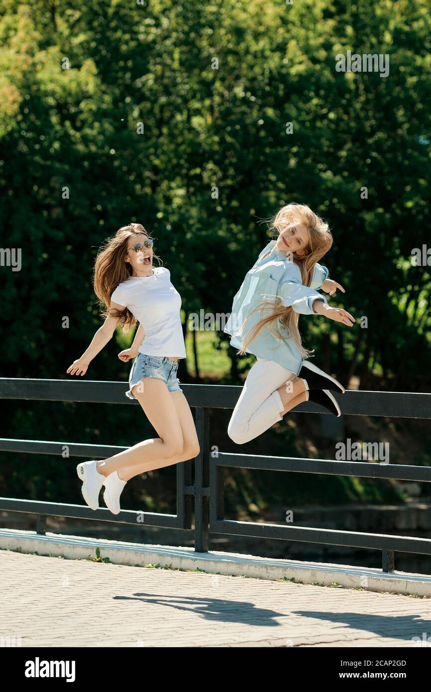 Deux positife et drôles filles sautant ensemble Banque D'Images
