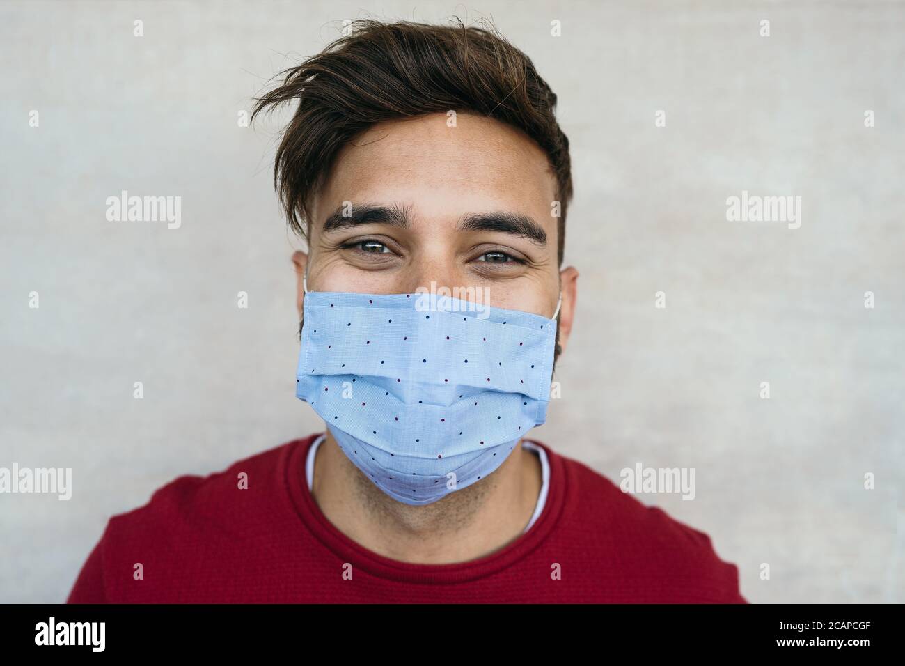 Jeune homme portant un masque facial portrait - garçon latin utilisant un masque facial protecteur pour prévenir la propagation du virus corona Banque D'Images