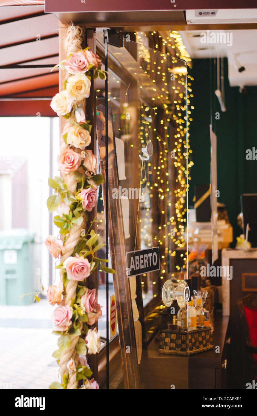 Vue sur l'avant d'une entrée du magasin décorée de lumières de noël et de roses roses à Vila Germanica, Blumenau - Brésil pendant l'après-midi. Banque D'Images