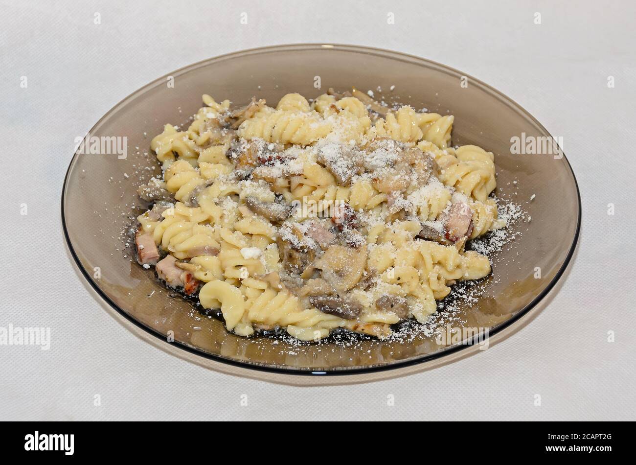 Assiette transparente avec pâtes spaghetti carbonara à la crème, champignons, bacon. Banque D'Images