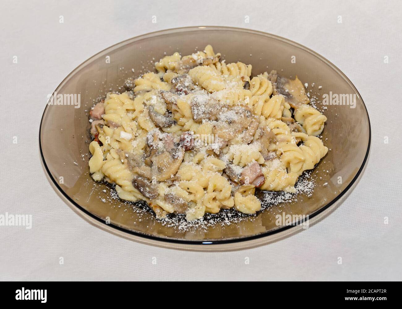 Assiette transparente avec pâtes spaghetti carbonara à la crème, champignons, bacon. Banque D'Images