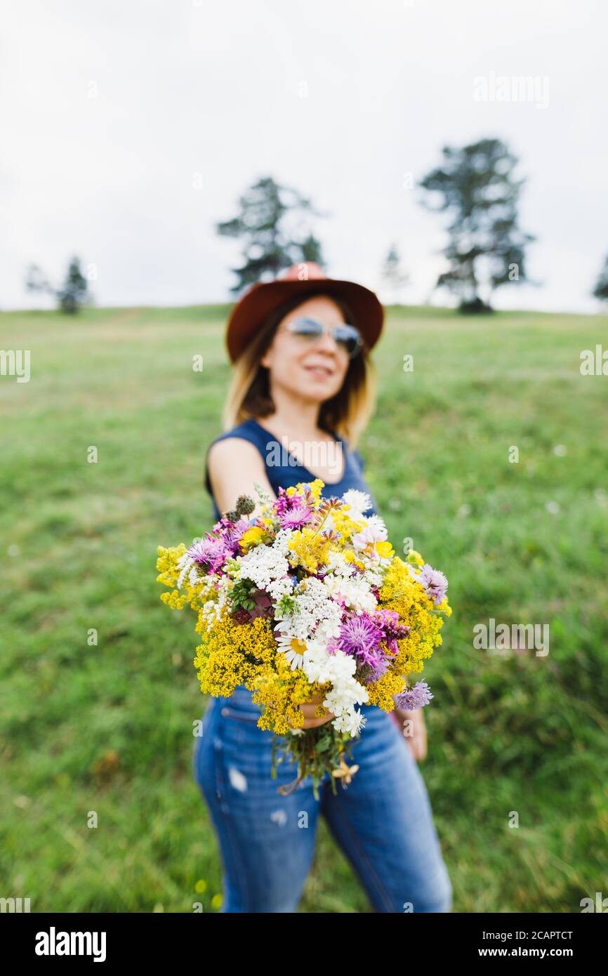 Jeune femme tenant un bouquet de fleurs dans le champ Banque D'Images