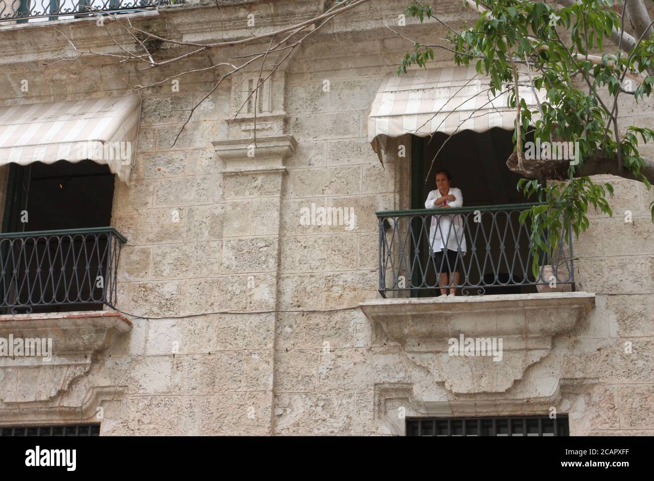 Femme donnant sur le balcon de la maison de style colonial, la Havane, Cuba Banque D'Images