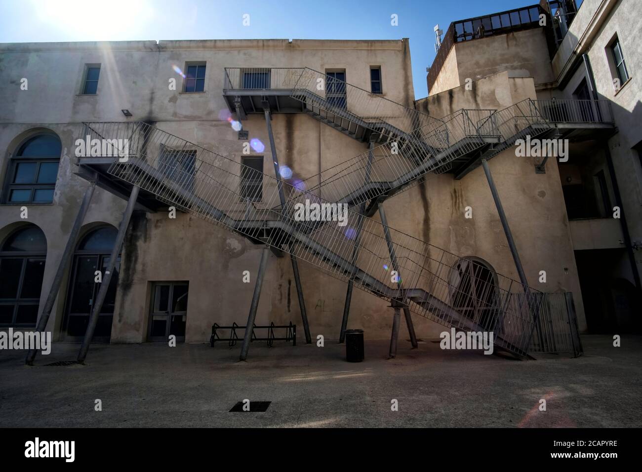 Vue sur les escaliers modernes d'urgence sur l'ancien bâtiment du département d'architecture de l'université à Alghero, en Italie Banque D'Images