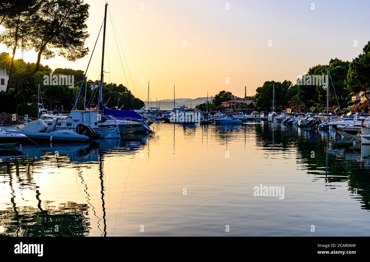Santa Ponsa, Majorque, Espagne. Coucher de soleil avec soleil orange dans le port avec voiliers, bateaux. Banque D'Images