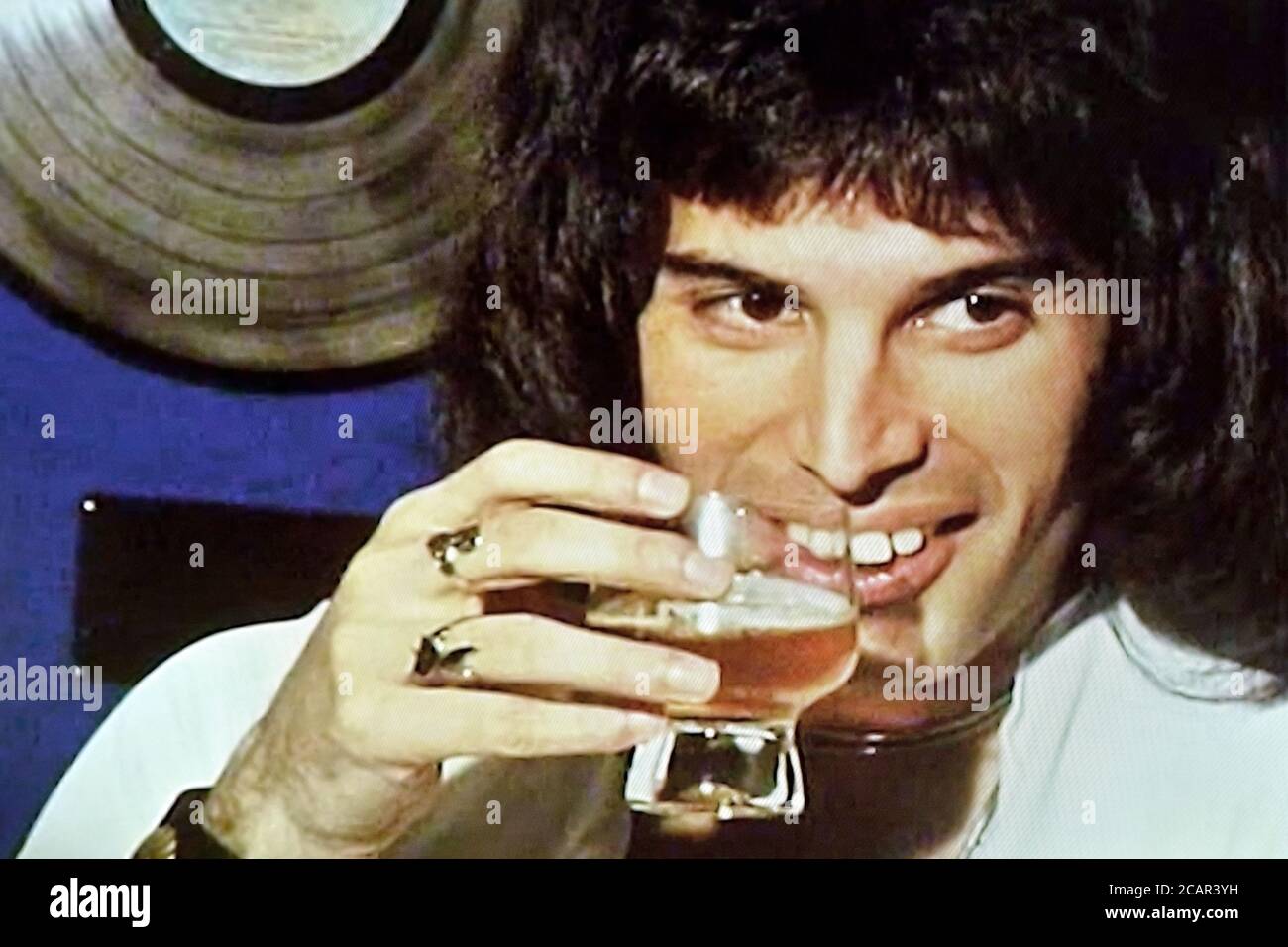 Freddie Mercury prendre un verre pendant l'interview de Perth 1976 Banque D'Images