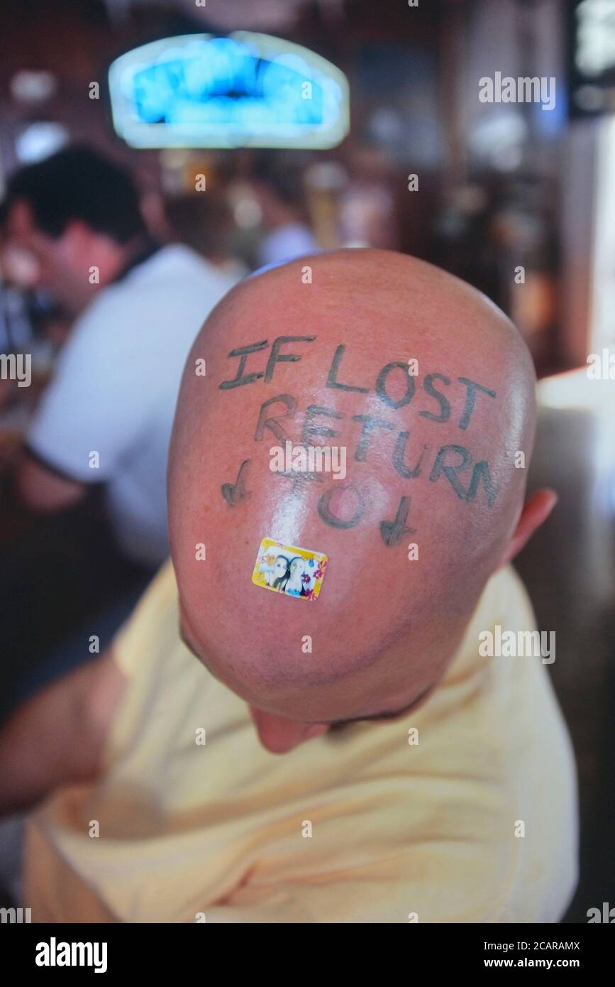 Client chauve avec un message « si perdu, veuillez retourner » écrit sur sa tête à Sloppy Joe's bar, Key West. Florida Keys. ÉTATS-UNIS Banque D'Images