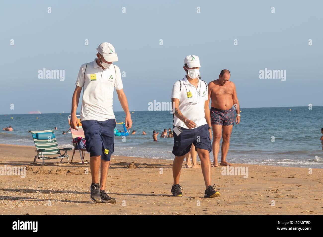 Punta Umbria, Huelva, Espagne - 7 août 2020: La garde de plage de Junta de Andalucia contrôle la distance sociale et l'utilisation du masque de protection Banque D'Images